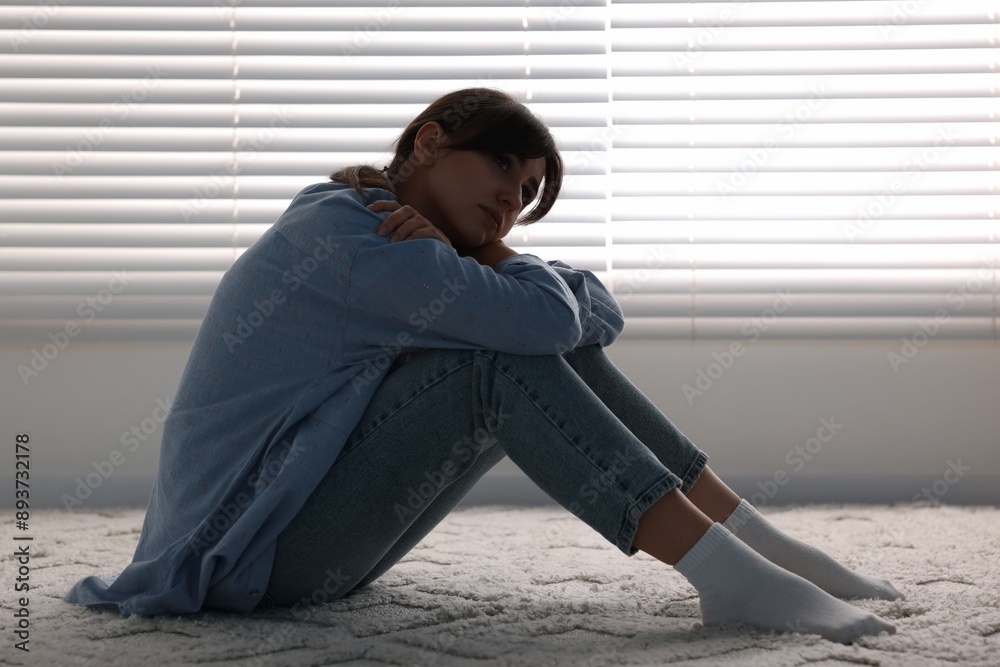 Poster Loneliness concept. Sad woman sitting on floor at home