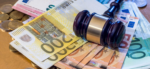 hammer gavel on euro banknotes on rusty table