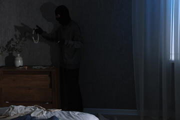Thief stealing jewels in foreign house, space for text. Burglary