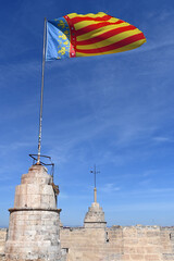 Community of Valencia flag on top of the Serrano Towers in Valencia,Spain