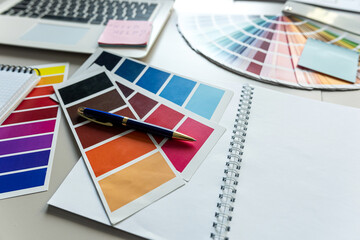 Desktop with aptop and Notepad for notes color catalog, creative workplace