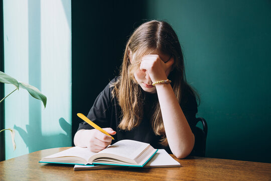 Young female student studying hard at a desk