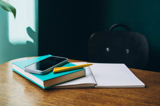 Smartphone and stationery on a desk signaling back to school