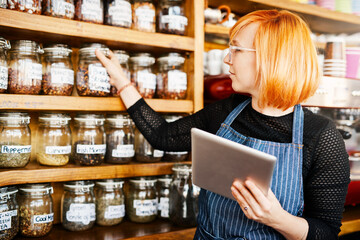 Barista, woman and tablet for coffee shop inventory or online order on website in startup cafe. Small business owner, waiter and review with technology for stock menu or price checklist in store