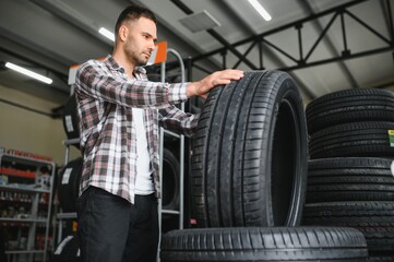A young man buys new tires for his car