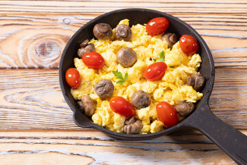 Homemade scrambled eggs with mushrooms and cherry tomatoes