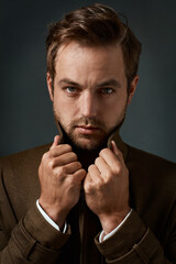 Handsome man, portrait and fashion with vintage style of serious mafia in studio on a dark background. Face of cool, young male person or attractive model with stylish jacket, coat or clothing attire