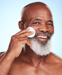 Black man, face and skincare in studio with cotton pad for cleaning, toner and skin moisturizer. Mature person, portrait and dermatology on blue background with beauty swab for wellness or treatment