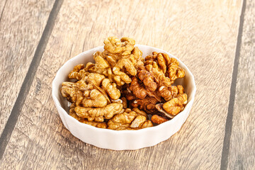 Cracked unshelled walnut in the bowl