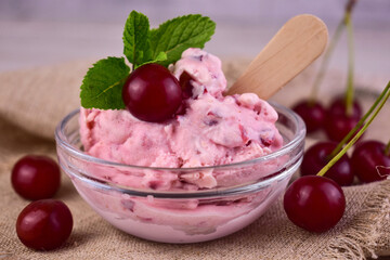 Cherry ice cream in a glass bowl with fresh cherries.Close-up.
