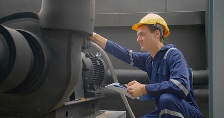 A Engineer man looking inspecting maintenance insulated pipelines valve pump control on the roof at...