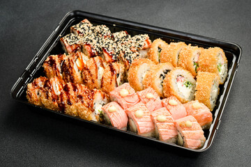 Sushi set. Sushi rolls with fish, caviar and avocado in a plastic disposable dish. Food delivery.