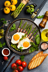 Delicious Breakfast: A plate with fried asparagus, bacon and fried eggs.