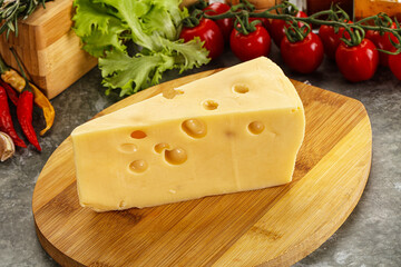 Swiss Maasdam cheese triangle over board