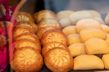 Close-up view of various freashly baked sweet buns lying on shelf in bakery or cafe. Small business. Soft focus. Food background. Pastry theme.