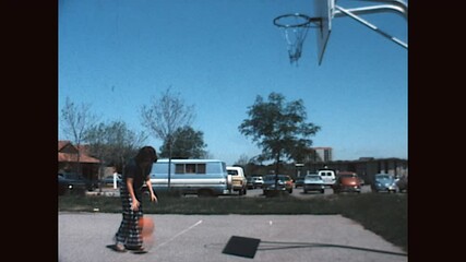 Woman Playing Basketball 1975 - A woman practices shooting baskets on a court at UC Berkeley in 1975. 