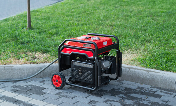 Portable electric generator on the street in summer day. The generator provides with electricity electrical appliances in nature. 