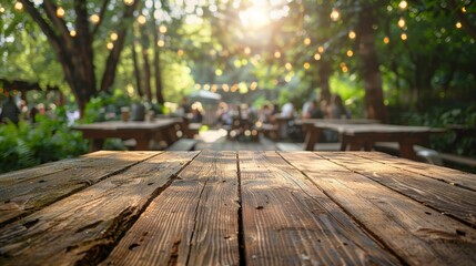 Fototapeta premium A rustic wooden tabletop with a blurred background of a sunny outdoor gathering in a garden setting