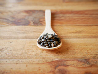 Raw lentils in a wooden spoon. View from above
