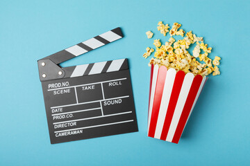 Tasty popcorn in buckets and cold cola drinks with cinema tickets, movie clapper and 3D eyeglasses...
