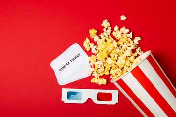 Tasty popcorn in buckets and cold cola drinks with cinema tickets, movie clapper and 3D eyeglasses...