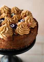 Caramel cake with caramel cream on top. Beautifully decorated with flowers and nuts. Birthday cake.