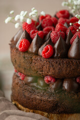 Chocolate Cake with raspberries on a wooden table. Beautifully decorated.