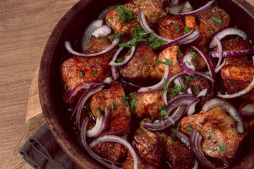 fried meat, pork kebab, ketsi in a clay pan, with red onions and herbs, homemade, no people,