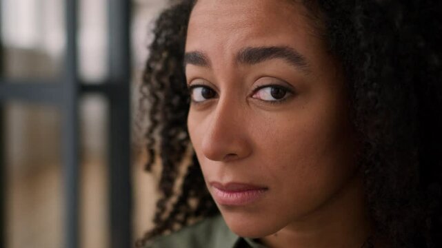 Depressed worried sad African American woman girl alone at home concern problem upset desperate ethnic female lady face tired frustrated lonely depressed regret sorrow health trouble looking at camera