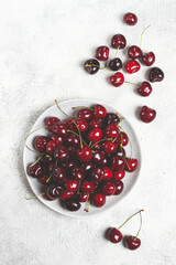 red cherry, cherry berry, scattered on a plate, top view, no people,