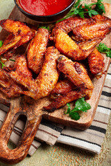 fried in the oven, chicken wings, with spices, tomato sauce, on a cutting board, gray background, no people, homemade,