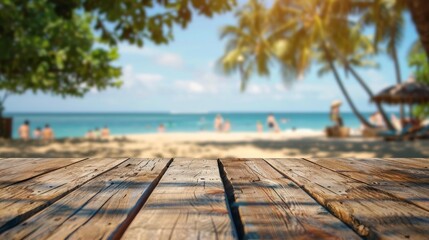 Wooden planks in focus with a blurred background of a tropical beach with palm trees ocean sand and people