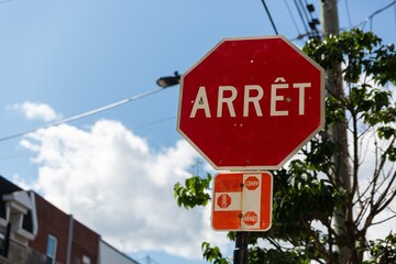 Fototapeta premium Red Stop Sign With French Arrêt Text in Urban Setting