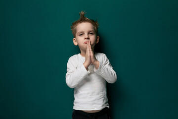 Little Boy Standing in Front of Green Wall