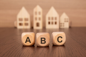 cubes with message ABC surrounded by wood home. Always Be Closing concept