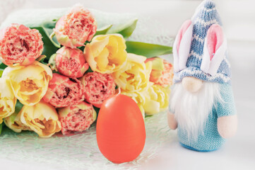 Easter composition on a light background. Cute white rabbits, yellow and pink tulips, Easter eggs symbol of the Easter holiday. Home and office decoration. Happy Easter holiday