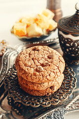 Delicious sweet cookies with chocolate chips, homemade chocolate cookies in oriental serving for the holidays with coffee and Turkish delight. Sweets on the table