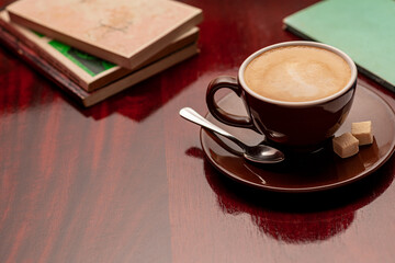 8-ounce latte-style coffee mug with books around it.