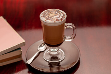 12 ounce Mocha style coffee cup with books around it.