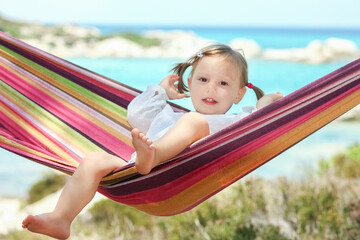 happy child by the sea on hammock in greece background