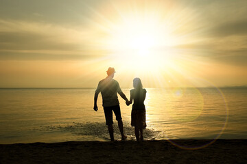 Fototapeta premium A happy couple by the sea on nature in travel silhouette