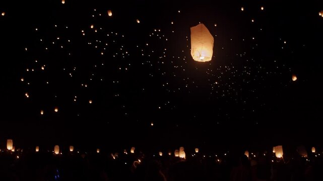 Launching Chinese paper lantern into night sky 