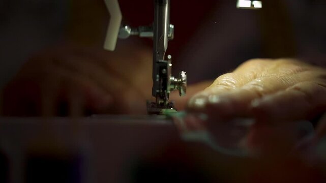 Close-up of a senior woman sewing colorful fabric on a machine. retirement concept