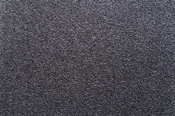 Fototapeta premium Sandpaper texture background gives a beautiful pattern of black sand grains on sandpaper, suitable as a background for inserting text. Copy Space for designers to use on sandpaper.