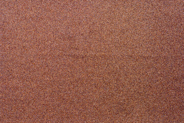 Blurred background of brown sandpaper for inserting text. Sandpaper backgrounds are made from natural materials for polishing wood and steel to a smooth surface before painting.