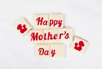 Modern square cookies with marmalade filling in the shape of the words happy mother's day and heartб of a mother and child. Top view. Mothers Day