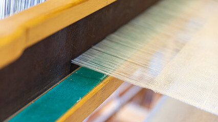 Weaving, traditional crafts,Close-up of a loom weaving, Woven silk,using cotton and silk string stretch and woven by using mechanic wooden machine to weave,