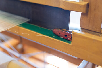 Weaving, traditional crafts,Close-up of a loom weaving, Woven silk,using cotton and silk string stretch and woven by using mechanic wooden machine to weave,