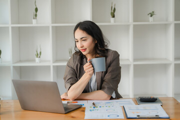 Focused Female Professional Navigating the Business World: A young Asian businesswoman, engrossed...