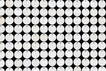 Naklejka premium Close-up of a geometric pattern composed of metal circles mounted on a black wall